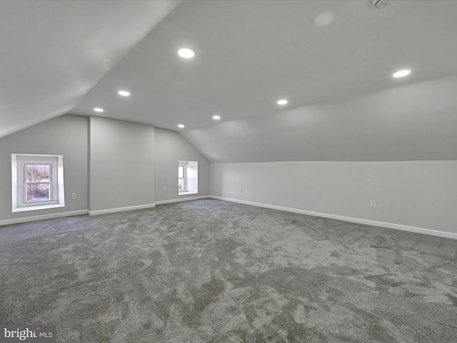 additional living space featuring lofted ceiling and carpet floors