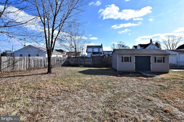 view of yard featuring a fenced backyard, a storage unit, and an outbuilding