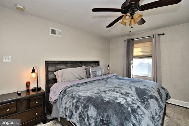 bedroom featuring a ceiling fan, visible vents, and baseboards