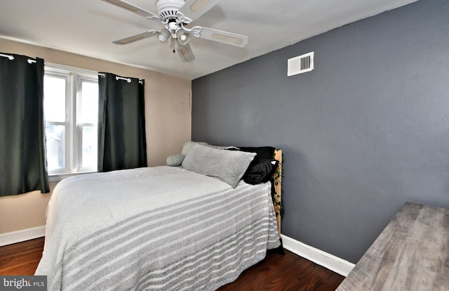 bedroom featuring visible vents, baseboards, and wood finished floors