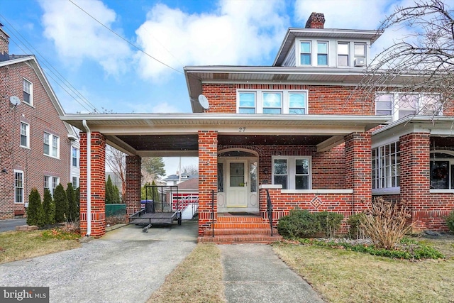 traditional style home with covered porch, a chimney, and brick siding