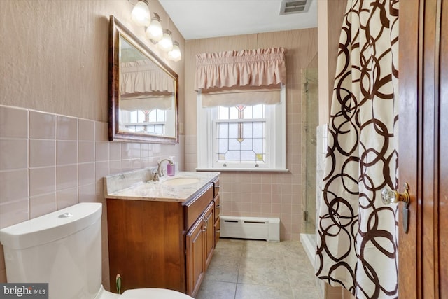 bathroom with visible vents, tile patterned flooring, vanity, a baseboard heating unit, and tile walls