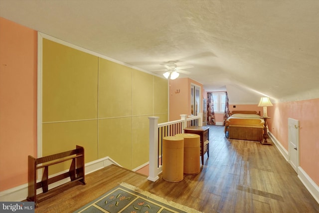 bedroom featuring baseboards, vaulted ceiling, and wood finished floors