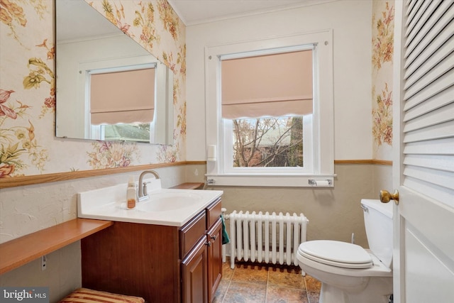 bathroom with a closet, toilet, radiator heating unit, and wallpapered walls