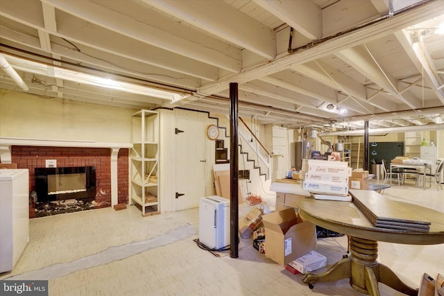 unfinished basement with a brick fireplace, water heater, stairway, and tile patterned floors