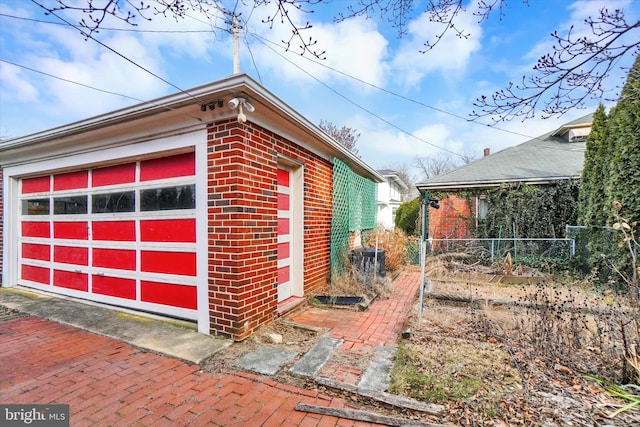 view of side of property with an outbuilding, brick siding, and a garage