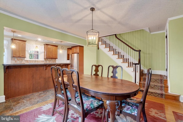 dining space featuring stairs, baseboards, and crown molding