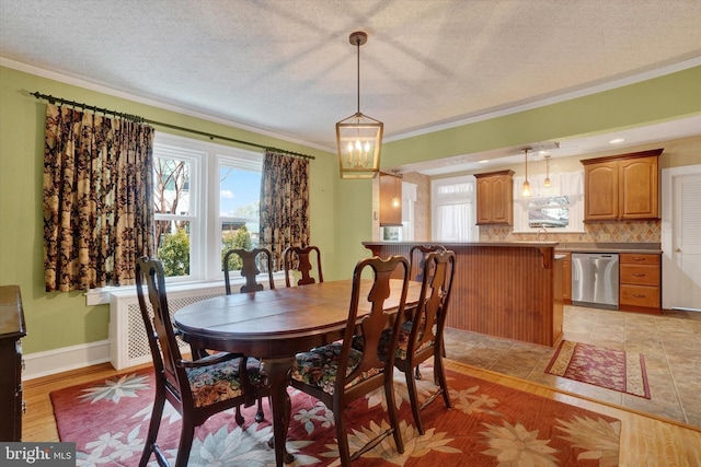 dining space with a textured ceiling, baseboards, and crown molding