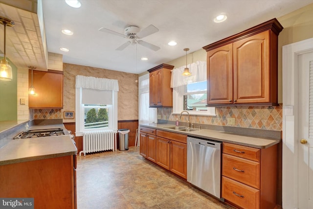 kitchen featuring dishwasher, radiator heating unit, brown cabinets, pendant lighting, and a sink