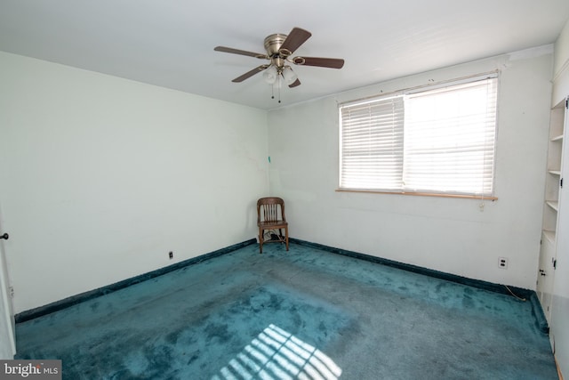 carpeted empty room with baseboards and a ceiling fan