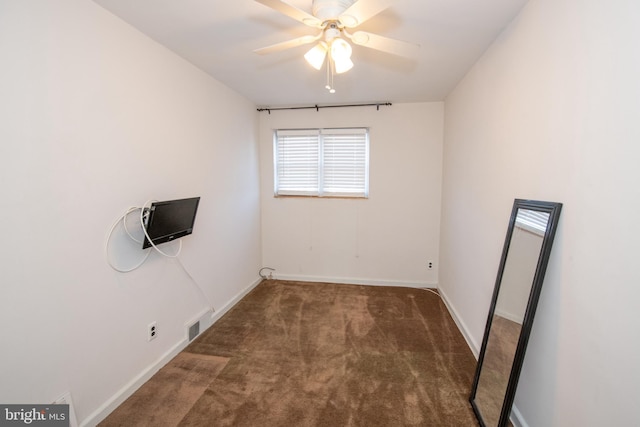 carpeted empty room featuring ceiling fan, visible vents, and baseboards