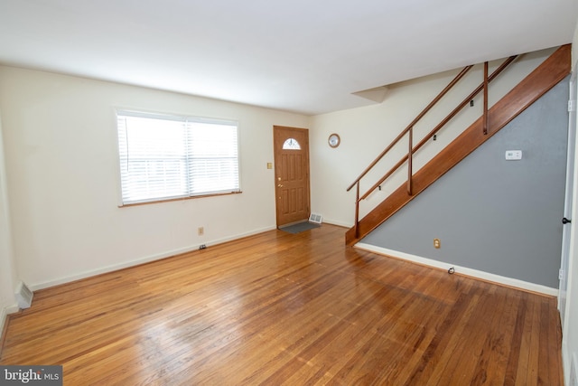 entrance foyer featuring visible vents, stairs, baseboards, and hardwood / wood-style floors