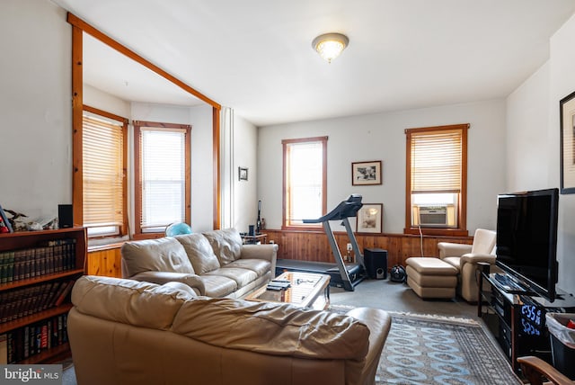 living room with carpet flooring, cooling unit, and wood walls