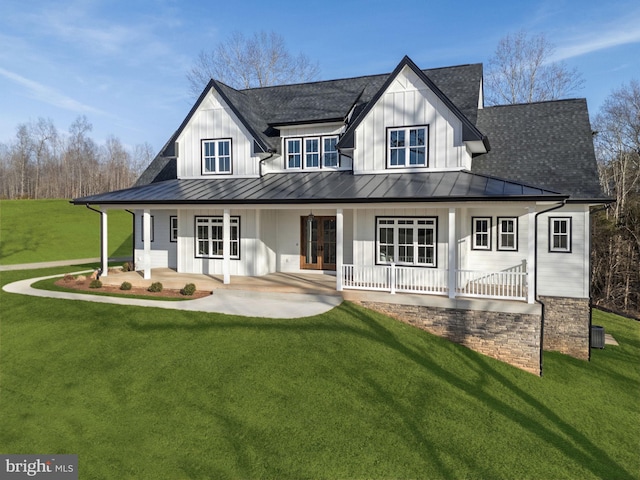 view of front of property featuring a standing seam roof, a front lawn, and board and batten siding