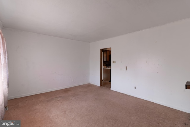 unfurnished room with light colored carpet and baseboards