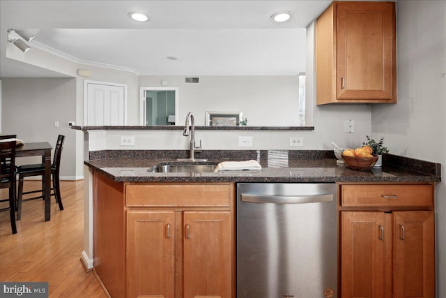 kitchen with a sink, visible vents, stainless steel dishwasher, light wood-type flooring, and dark stone countertops