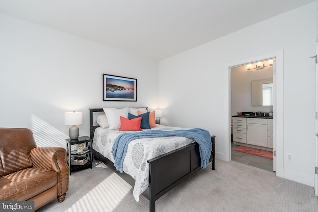 bedroom featuring light carpet and connected bathroom