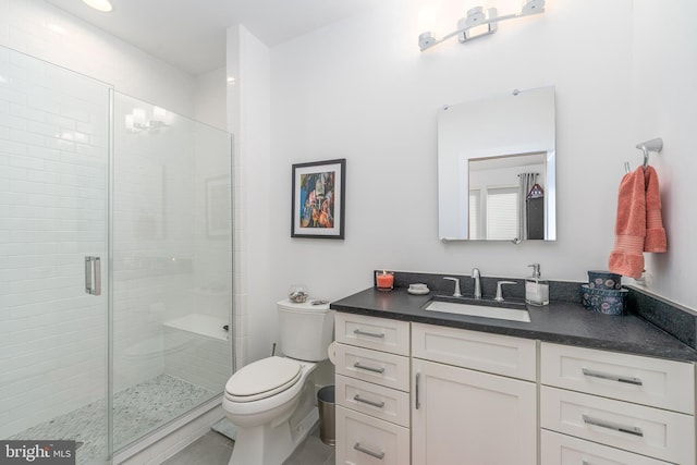 bathroom featuring toilet, a stall shower, and vanity