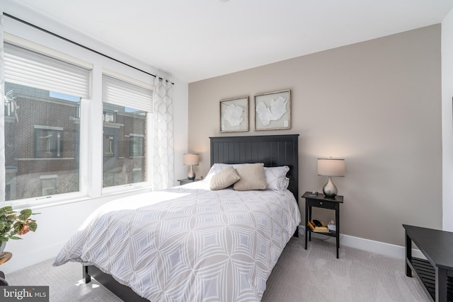 bedroom with light carpet and baseboards