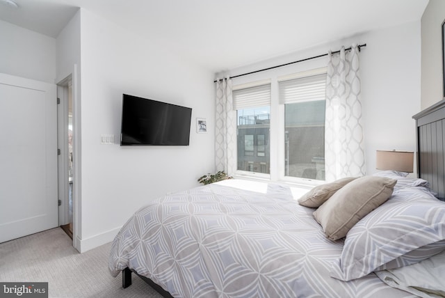 bedroom with baseboards and light colored carpet