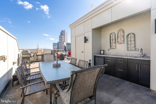 view of patio / terrace with a view of city, outdoor dining area, a sink, and grilling area