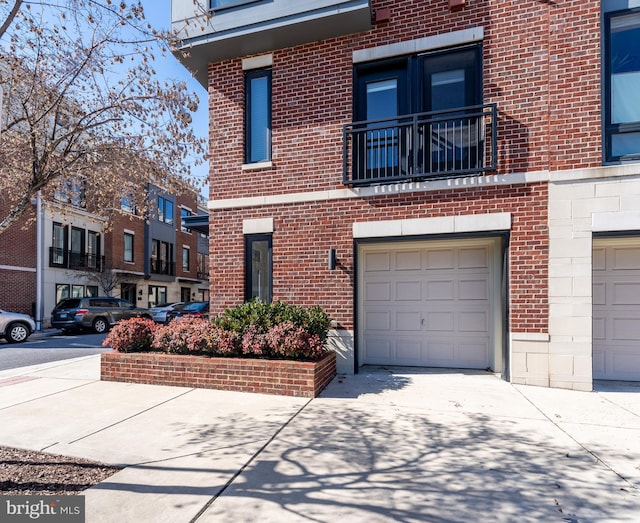 view of front of home featuring driveway, stone siding, an attached garage, and brick siding