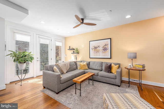 living room featuring light wood finished floors, recessed lighting, a ceiling fan, and baseboards