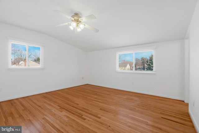 unfurnished room with a healthy amount of sunlight, lofted ceiling, ceiling fan, and light hardwood / wood-style floors