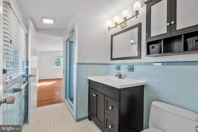 bathroom featuring tile walls, vanity, walk in shower, toilet, and tile patterned floors