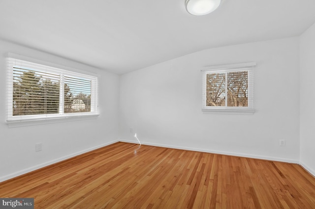 empty room featuring light hardwood / wood-style floors and lofted ceiling