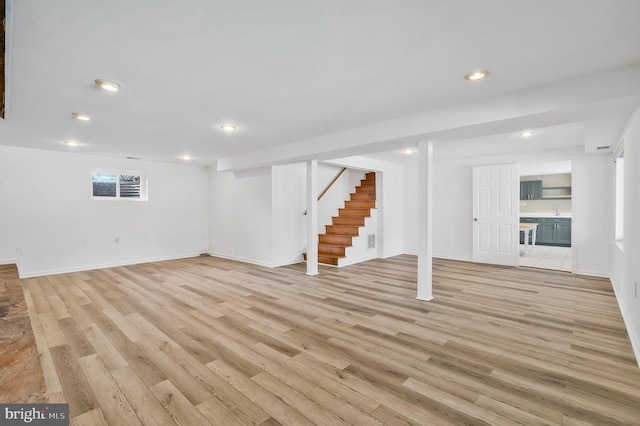 basement featuring light hardwood / wood-style floors and sink