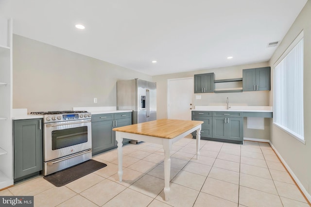 kitchen with light tile patterned flooring, appliances with stainless steel finishes, and sink