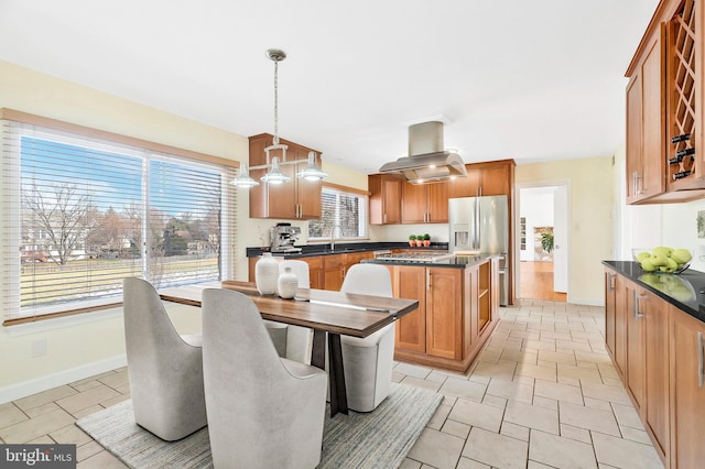 kitchen featuring decorative light fixtures, a kitchen island, sink, appliances with stainless steel finishes, and island exhaust hood