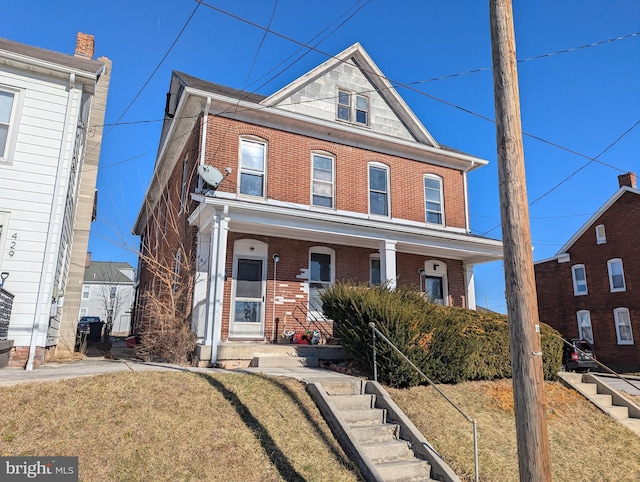 view of front of property featuring brick siding and a front lawn