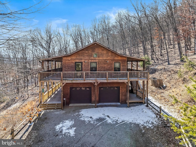 view of front of home with a garage, stairway, and a deck