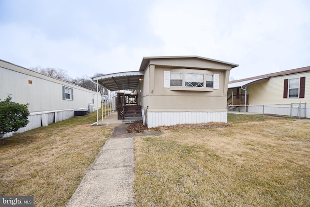 manufactured / mobile home with fence, a carport, and a front yard