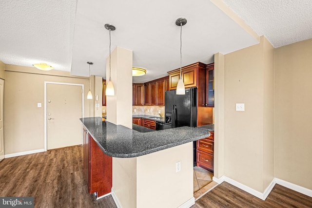 kitchen with black fridge with ice dispenser, a textured ceiling, dark hardwood / wood-style floors, kitchen peninsula, and hanging light fixtures