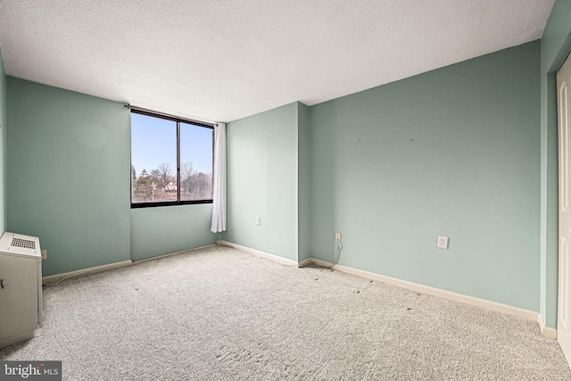 carpeted spare room featuring a textured ceiling