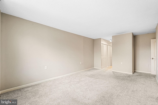 unfurnished bedroom with a textured ceiling, light carpet, and a closet