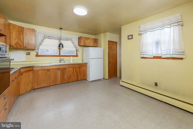 kitchen featuring white fridge, hanging light fixtures, a healthy amount of sunlight, and baseboard heating