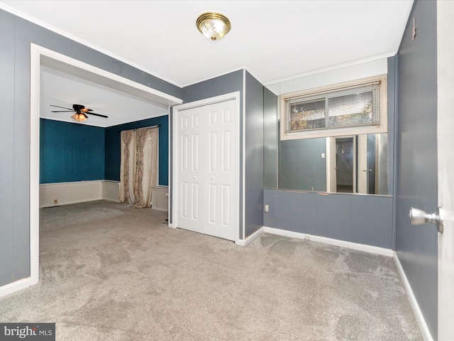 unfurnished bedroom featuring light carpet, a closet, and crown molding