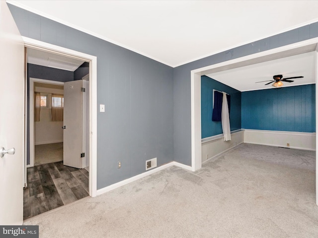 unfurnished room with ceiling fan, carpet flooring, and crown molding