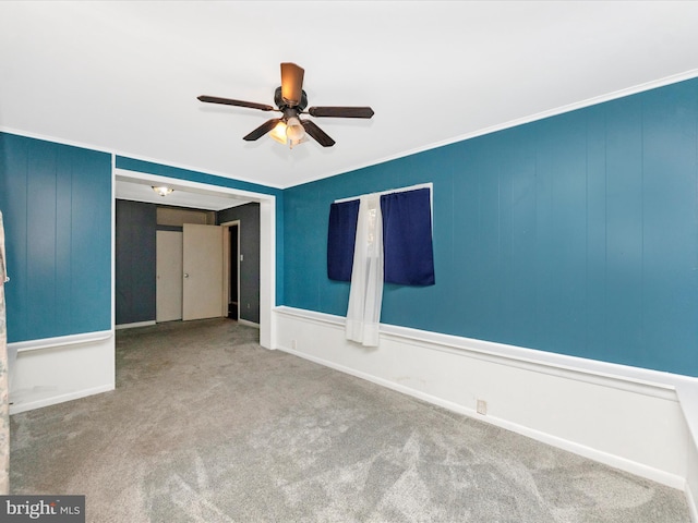 unfurnished room with ceiling fan, crown molding, and carpet floors