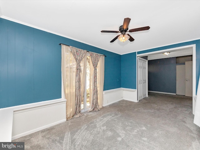 unfurnished bedroom featuring carpet, a closet, ornamental molding, and ceiling fan