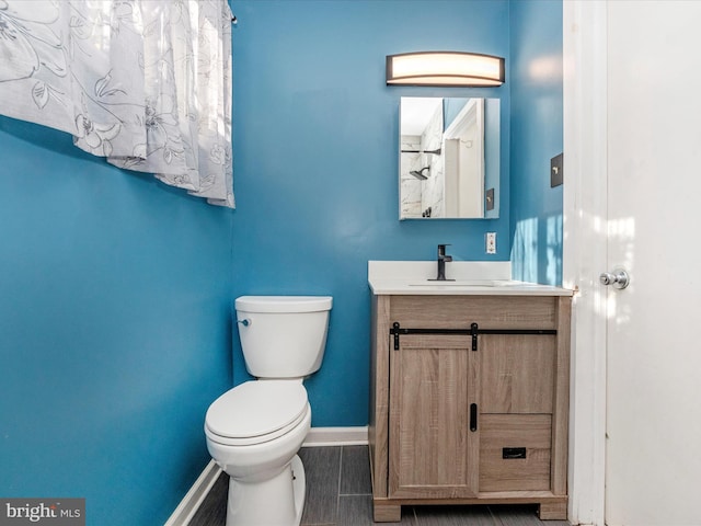 bathroom featuring wood-type flooring, vanity, and toilet