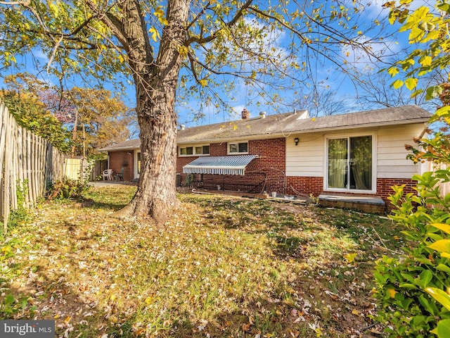 back of property featuring a lawn