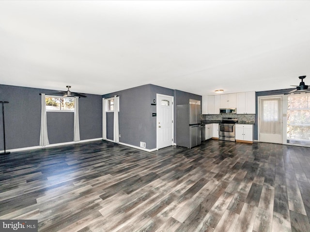 unfurnished living room with ceiling fan and dark hardwood / wood-style floors