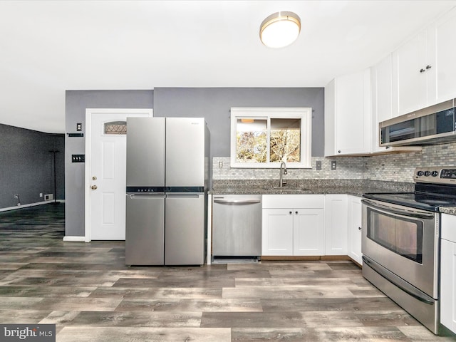 kitchen featuring appliances with stainless steel finishes, dark wood-type flooring, and white cabinetry