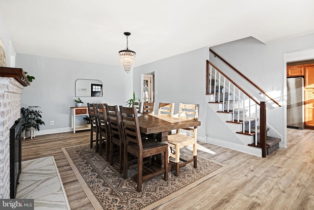 dining space with light hardwood / wood-style flooring and a chandelier