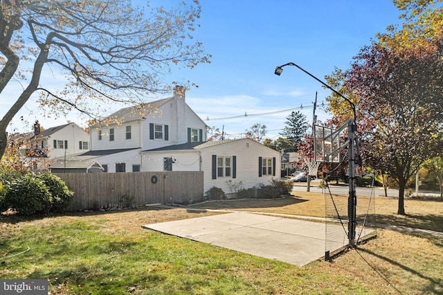 exterior space featuring a lawn and basketball court